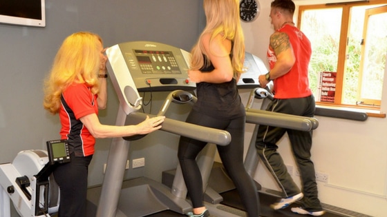 man and woman doing cardio in a gym