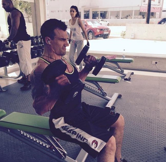 personal trainer doing bicep curls in the gym