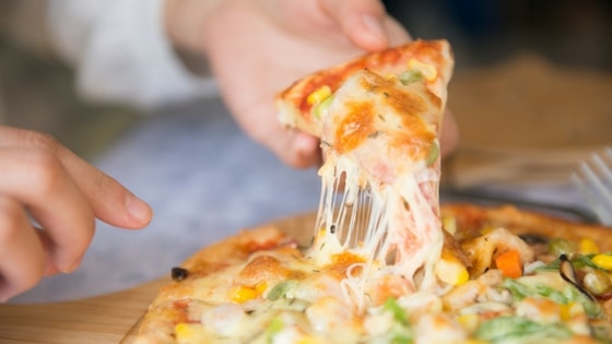picture of a hand grabbing a slice of pizza