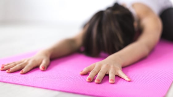 woman stretching her muscles on an exercise matt